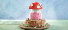 a mushroom shaped cake sitting on top of a wooden table next to a blue wall