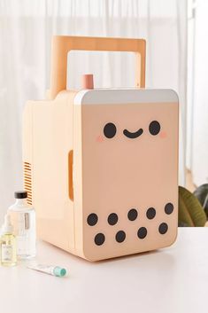 a box shaped like a robot sitting on top of a table next to a bottle