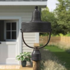 a light that is sitting on top of a pole in front of a house with a door