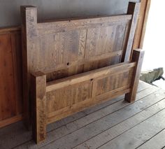 a wooden bench sitting on top of a wooden floor next to a wall and door