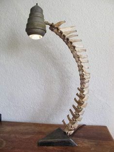 a lamp that is sitting on top of a wooden table in front of a wall