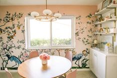 a dining room table with chairs and a vase on it