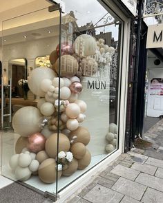 there is a display in the window of a store that has balloons all over it