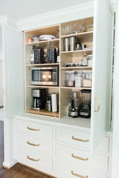 a kitchen with white cabinets and gold handles