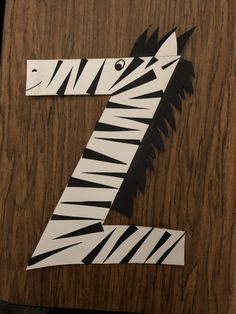 the number seven is made up of zebras on a wooden surface with black and white stripes