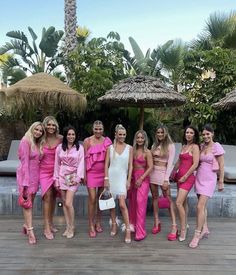 a group of women in pink dresses standing next to each other