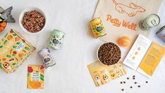 various foods and snacks are laid out on a white tablecloth with the words potty weet written in orange