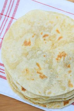 three tortillas sitting on top of a red and white towel