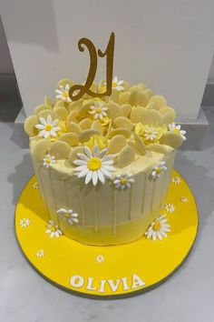 a yellow and white cake sitting on top of a table next to a sign with the number twenty