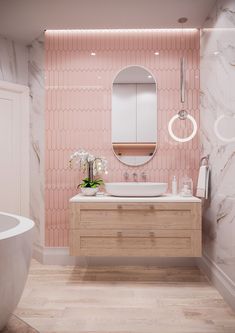 a bathroom with pink wallpaper and marble counter tops, white bathtub and round mirror