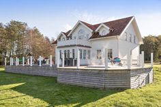 a large white house sitting on top of a lush green field