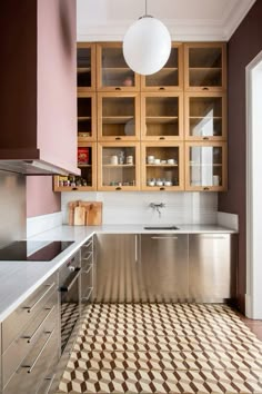 a kitchen with stainless steel appliances and checkered flooring on the tile in front of it