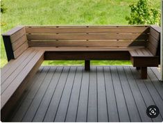 a bench sitting on top of a wooden floor next to a lush green field in the background