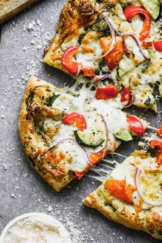 several slices of pizza with various toppings on a table