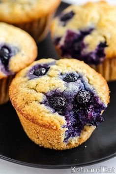 three blueberry muffins on a black plate