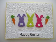 an easter card with three bunnies, carrots and a bunny in the center