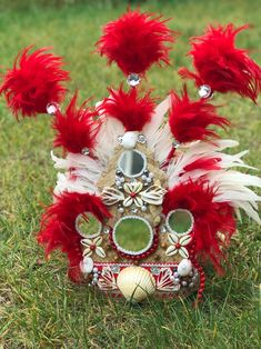 a red and white mask sitting in the grass