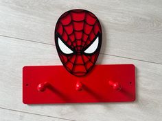 a spider - man head mounted on a red coat hook