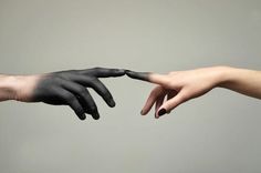 two hands reaching out to each other with black paint on their fingertipss and fingers