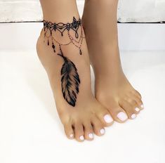 a woman's foot with a feather and beads tattoo on the bottom of it