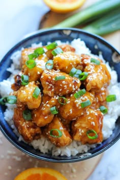 a blue bowl filled with orange chicken and rice