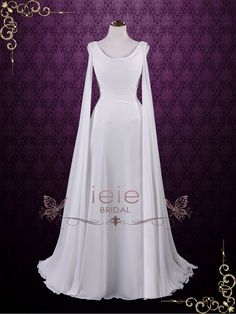 a white wedding dress with long sleeves and a cape on the shoulders, in front of a purple background