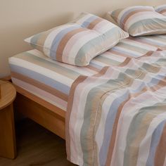 a bed with striped sheets and pillows on it