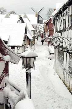 a street light covered in snow next to buildings