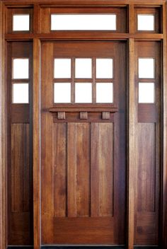 a wooden door with two sidelights on the front and side panels, in an open room