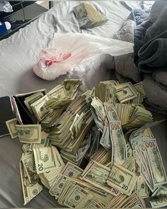 a pile of money sitting on top of a bed