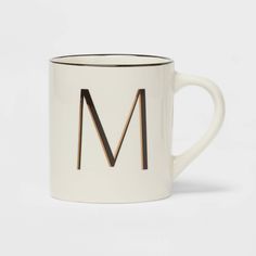 a white and black mug with the letter m on it