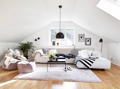 a living room filled with furniture and a skylight in the ceiling over it's windows