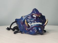 Awesome Japanese Samurai Oni Demon Mask will complement your cosplay costume or party look! Bright colors, easy to wear, super lightweight! Features: - Super Lightweight and Extra Durable (casted of Polyurethane plastic) - ALREADY FINISHED, POLISHED AND PAINTED - Attachment - Black cord + Straps Size: - width 6.7" (17 cm) - height 5.1" (13 cm)  Fits a regular human head You will receive: - Mask (finished, painted, varnished) *Doesn't need any finishing. Buy. Receive. Wear.* You can contact me fo Blue Oni Mask, Oni Demon Mask, Demon Mask, Oni Demon, Your Cosplay, Oni Mask, Half Mask, Chip Carving, Half Face Mask