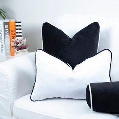 two black and white pillows on a white chair