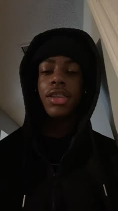 a young man with his eyes closed wearing a black hoodie