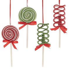 three lollipops are hanging on sticks with ribbons