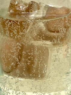 ice cubes and water in a glass with bubbles