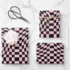 four pieces of pink and black checkered paper with scissors, pencils, and flowers