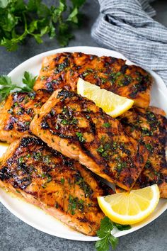 grilled salmon with lemon and parsley on a white plate