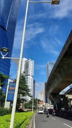 cars are driving down the road in front of tall buildings