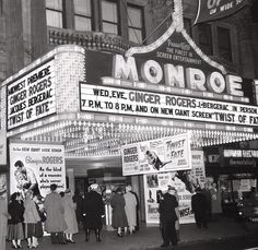 an old black and white photo of people standing in front of a marquee