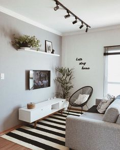 a living room filled with furniture and a flat screen tv on top of a wall