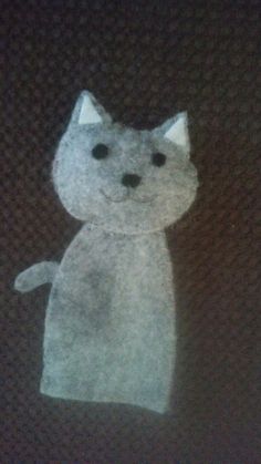 a drawing of a cat made out of paper on a black tableclothed surface