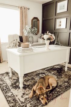 a dog laying on top of a rug in front of a white piano