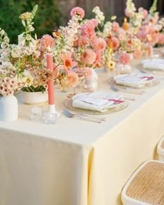 a long table is set with flowers and place settings for an elegant dinner party or celebration