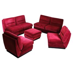 a group of red couches and chairs on a white background