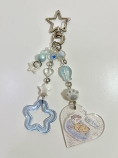 a key chain with two charms attached to it's sides and a star on the other side