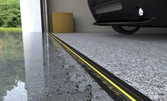 a car is parked in front of a building with water on the ground and yellow lines