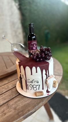 a cake decorated with wine and grapes on a table