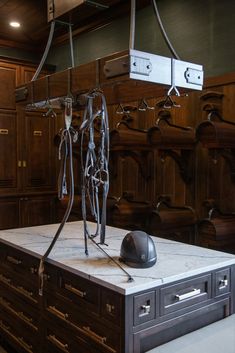 a room filled with lots of wooden cabinets and metal objects hanging from the ceiling above it